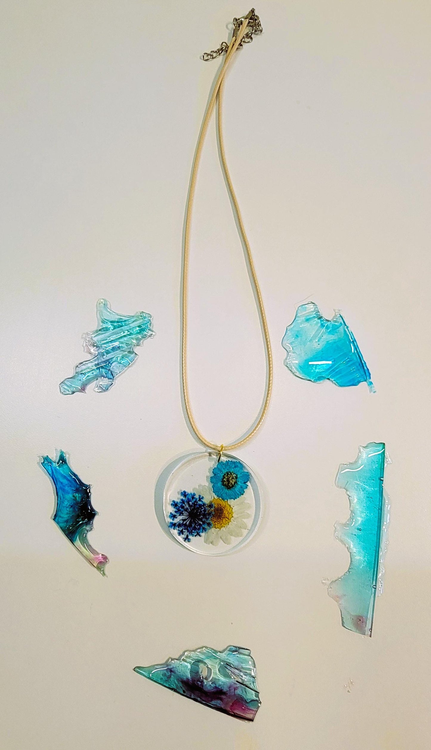 Exquisite handmade circular resin pendant containing white and blue flowers. A fantastic unique gift for a nature lover in your life.